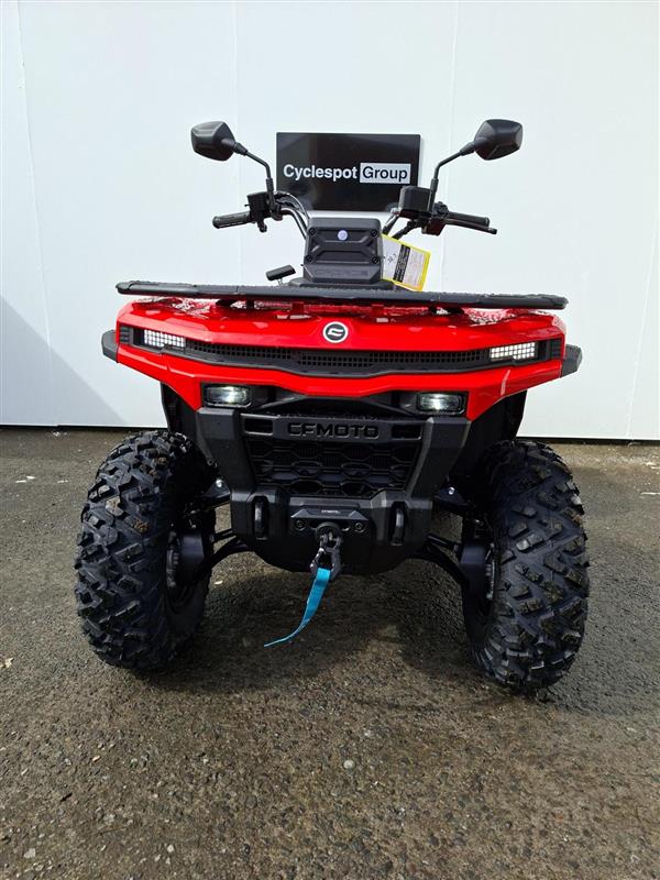 Load image into Gallery viewer, A red and black 2026 CFMOTO CFORCE C5 EPS all-terrain vehicle (ATV) photographed from the front, parked on a gray concrete floor against a white wall. A 'Cyclespot Group' sign is attached to the handlebars.