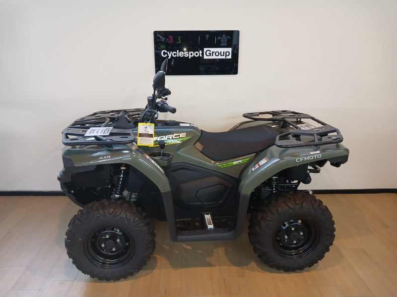 Load image into Gallery viewer, Left side of a green CF Moto C-Force 400 non-eps model on a wooden floor in front of a Cyclespot Group sign