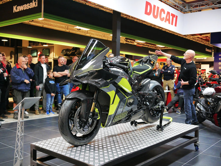 A large crowd of motorcycle enthusiasts gathering around the exclusive Ducati Lamborghini collaboration motorcycle on display at the Cyclespot Auckland showroom.