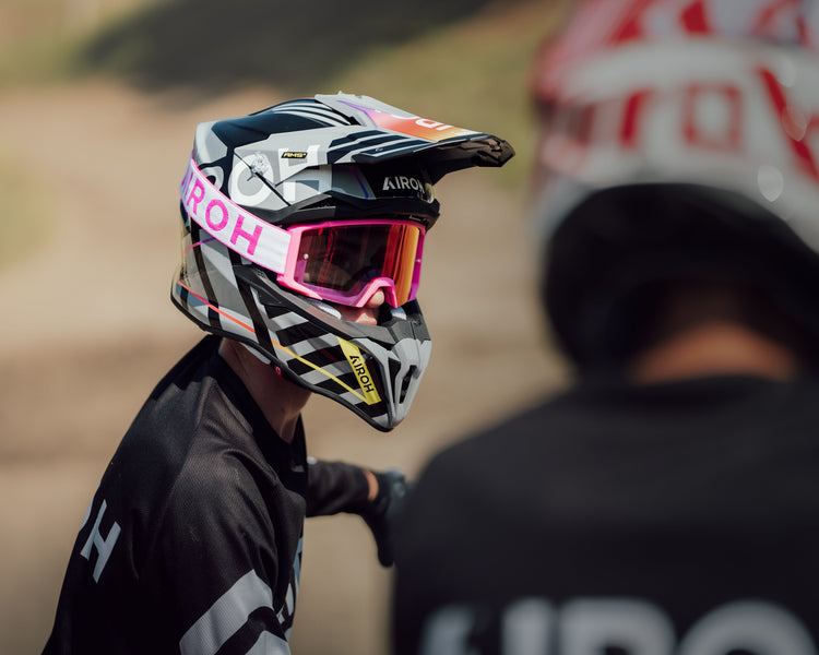 Motocross rider wearing an Airoh Aviator 3 helmet with pink graphics and matching pink Airoh goggles. A high-performance offroad helmet and goggle combination, available at Cyclespot Auckland, Taranaki, and Wellington.