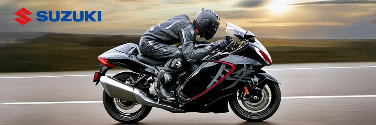 Black Suzuki Hayabusa sport motorcycle riding on a highway with Suzuki logo.