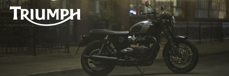 A Triump Bonneville t120 sitting outside a restaurant in a moody twilight settings