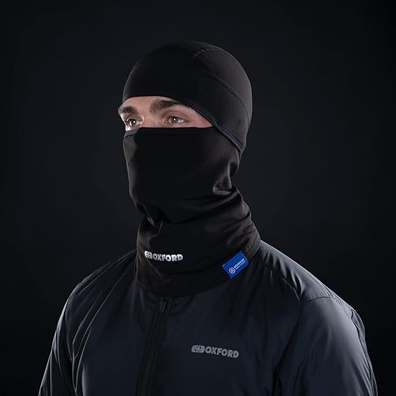 A rider wearing an Oxford black technical balaclava for wind protection and thermal comfort. This essential accessory fits perfectly under a helmet. Available at Cyclespot Auckland, Taranaki, Wellington, and online nationwide.