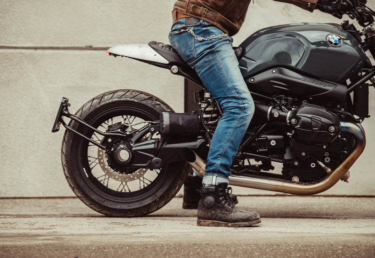 A motorcyclist riding a BMW R nineT in REV'IT! protective riding jeans. These men's motorcycle pants offer a stylish, casual look with high-tier safety for urban riders in Auckland, Taranaki, and Wellington seeking abrasion-resistant denim.