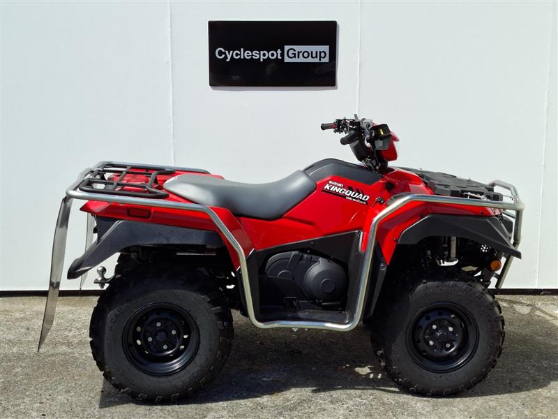 Load image into Gallery viewer, A red and black 2026 Suzuki KingQuad  LT-A500 four-wheeler ATV with a silver front bumper and rear rack, parked in front of a white wall with a 'Cyclespot Group' sign.
