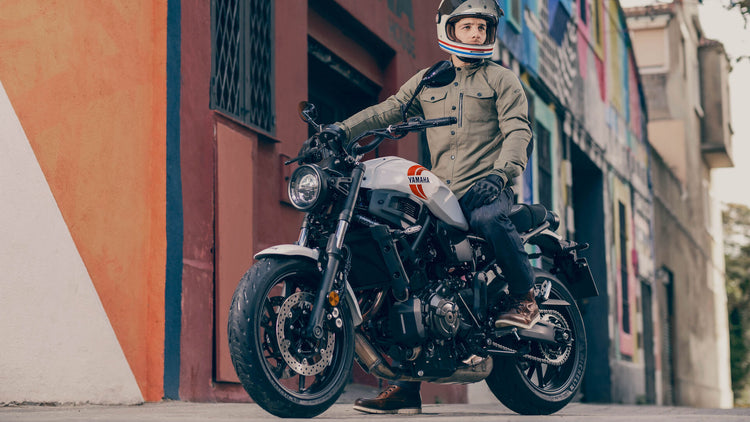 Male rider wearing a Shoei open-face helmet, Alpinestars riding overshirt, and  REV'IT! boots, available at Cyclespot Auckland, seated on a Yamaha XSR motorcycle in an urban street setting.