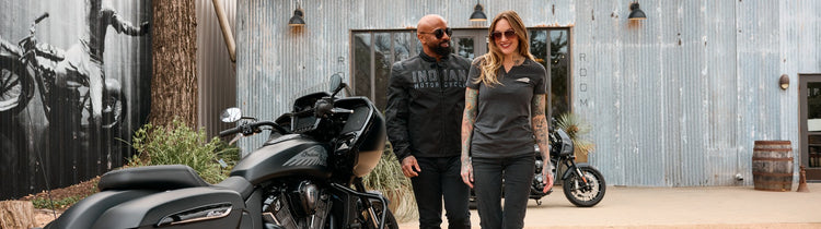 A man and woman in premium Indian Motorcycle lifestyle gear and casual apparel posing with touring motorcycles at Cyclespot NZ.