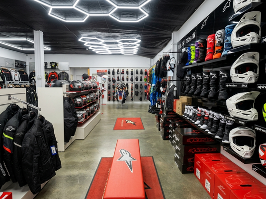 Inside Cyclespot Taranaki, New Plymouth’s destination for Alpinestars riding gear. This modern showroom features premium motorcycle boots, helmets, and safety apparel under distinctive hexagonal LED lighting for the local riding community.