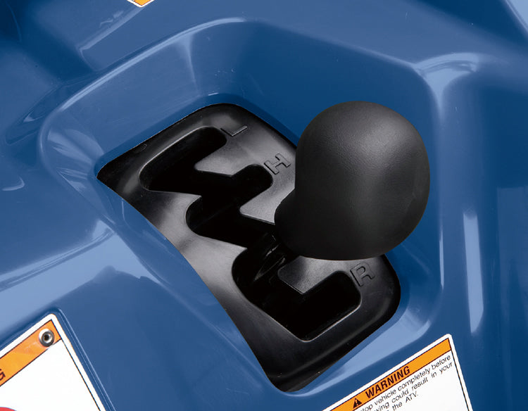 Load image into Gallery viewer, Close-up of a black manual gear shift knob inserted into a black shift tunnel of a blue atv body.
