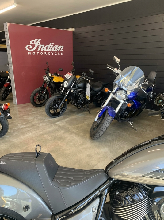 Interior view of the Cyclespot Taranaki showroom, featuring a dedicated Indian Motorcycle section with the official logo wall and a lineup of models, including the Chief and FTR, next to other cruisers.